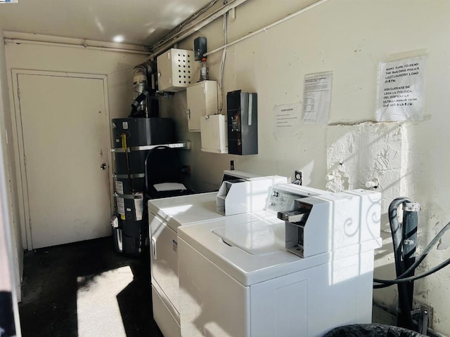 laundry area featuring strapped water heater and washer and dryer