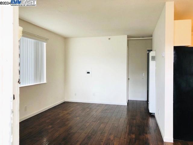 unfurnished room featuring dark wood-type flooring