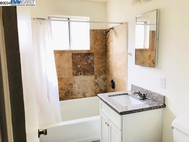 full bathroom with vanity, toilet, and shower / tub combo with curtain