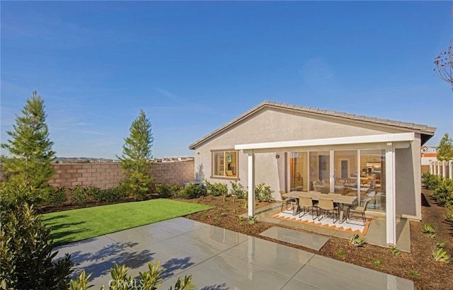 back of property featuring a yard and a patio area