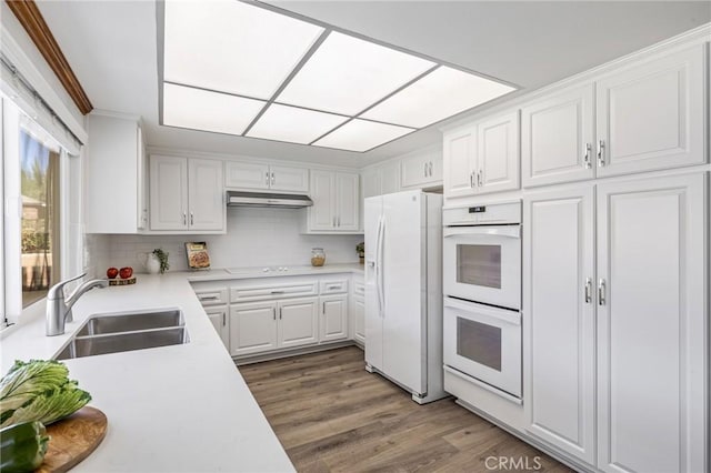 kitchen featuring white appliances, white cabinets, dark hardwood / wood-style flooring, sink, and ornamental molding