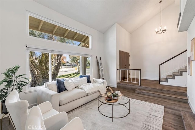 living room featuring high vaulted ceiling, an inviting chandelier, and dark hardwood / wood-style floors