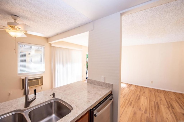 kitchen featuring stainless steel dishwasher, a textured ceiling, light hardwood / wood-style flooring, ceiling fan, and sink