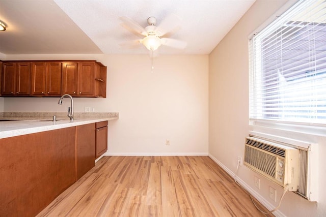 kitchen featuring sink, ceiling fan, and light wood-type flooring