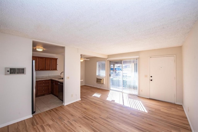 interior space featuring sink, ceiling fan, light hardwood / wood-style floors, and a textured ceiling