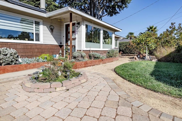 doorway to property with a lawn