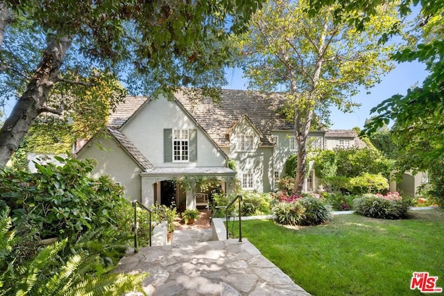 tudor home with a front lawn