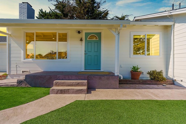 doorway to property featuring a lawn