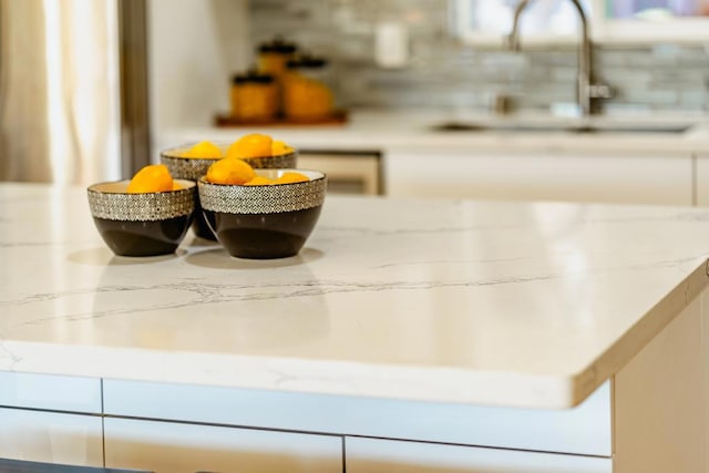 details featuring light stone counters and sink