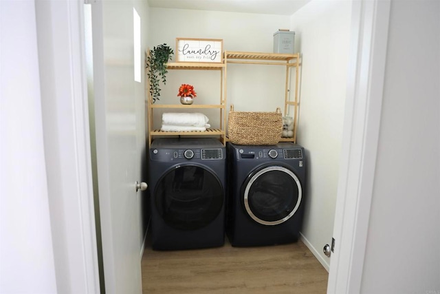 clothes washing area featuring washing machine and dryer and hardwood / wood-style floors