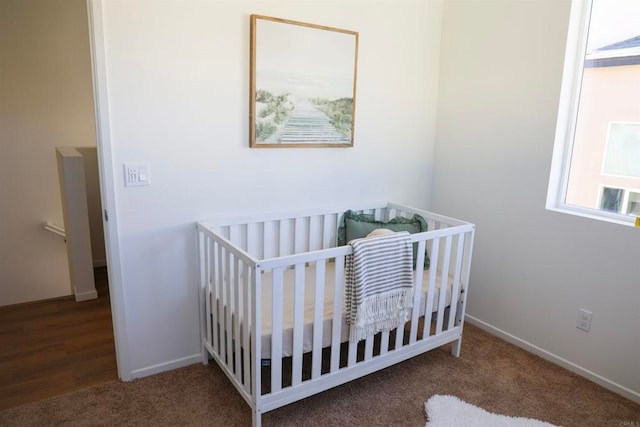 bedroom featuring a crib and carpet floors