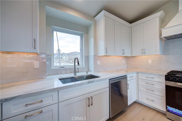 kitchen featuring white cabinets, custom exhaust hood, sink, and appliances with stainless steel finishes