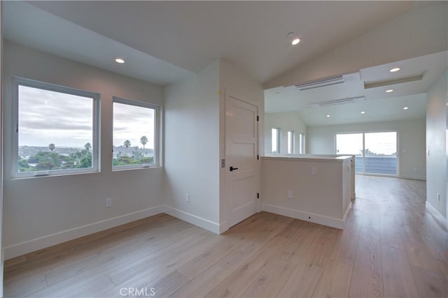 empty room with light hardwood / wood-style flooring and vaulted ceiling