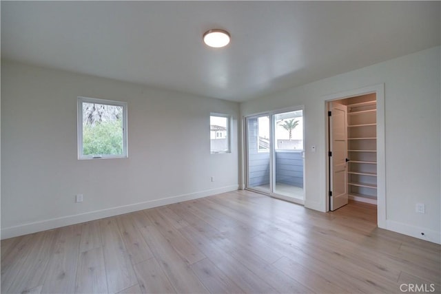 empty room featuring a wealth of natural light and light wood-type flooring