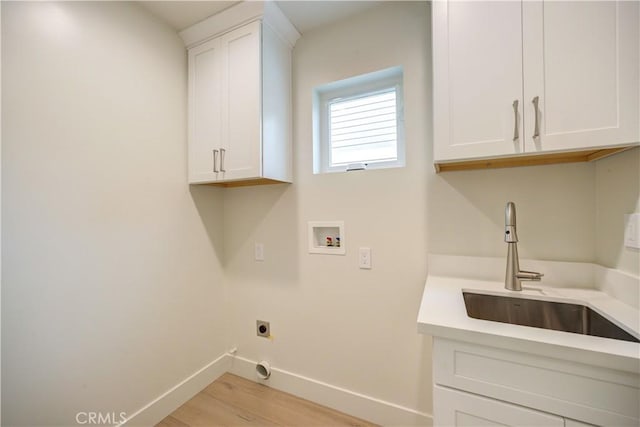 laundry area with sink, cabinets, washer hookup, hookup for an electric dryer, and light wood-type flooring