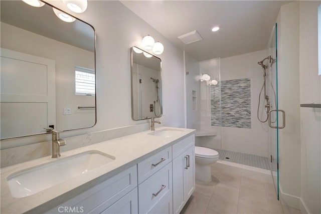 bathroom with tile patterned flooring, vanity, toilet, and walk in shower