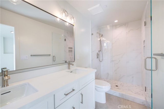 bathroom featuring tile patterned floors, vanity, toilet, and a shower with shower door