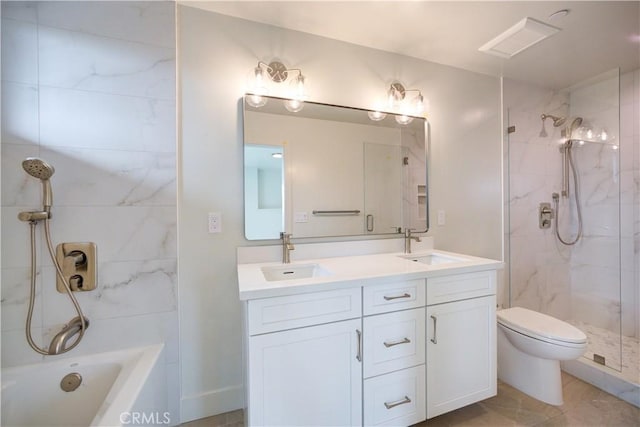 bathroom featuring tile patterned flooring, vanity, toilet, and tiled shower