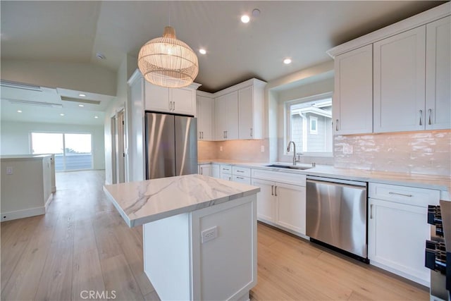 kitchen featuring sink, white cabinets, vaulted ceiling, and appliances with stainless steel finishes