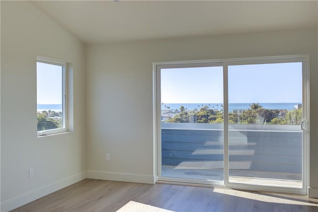 spare room with a water view and light wood-type flooring