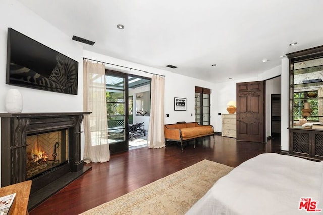 bedroom with access to outside and dark hardwood / wood-style floors