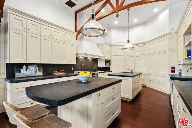 kitchen featuring pendant lighting, backsplash, a center island, and dark wood-type flooring