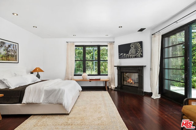 bedroom with hardwood / wood-style flooring and multiple windows