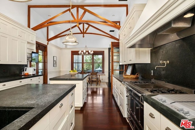 kitchen featuring pendant lighting, premium range hood, vaulted ceiling, decorative backsplash, and a notable chandelier