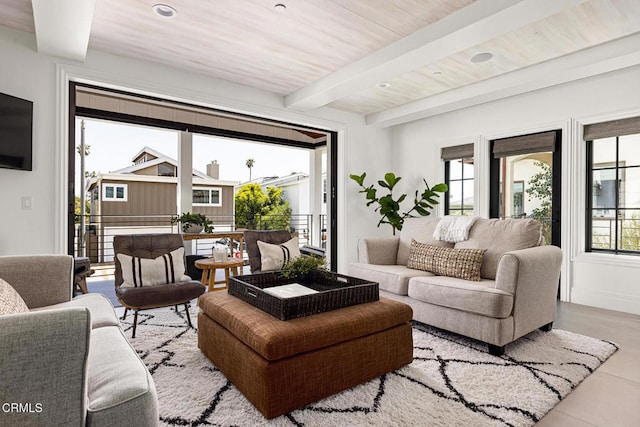 living room with beam ceiling, light tile patterned floors, and wood ceiling