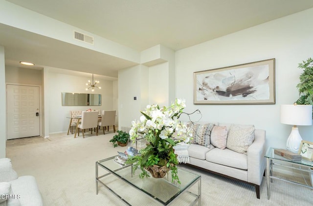 carpeted living room with a chandelier