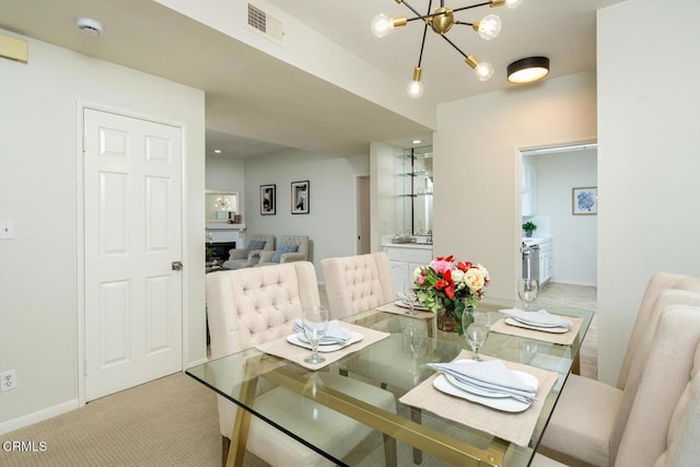 dining room with light carpet and a notable chandelier