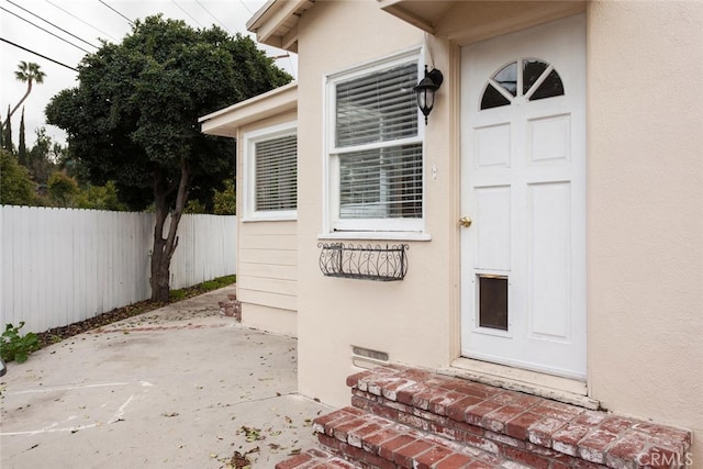 view of exterior entry with a patio area