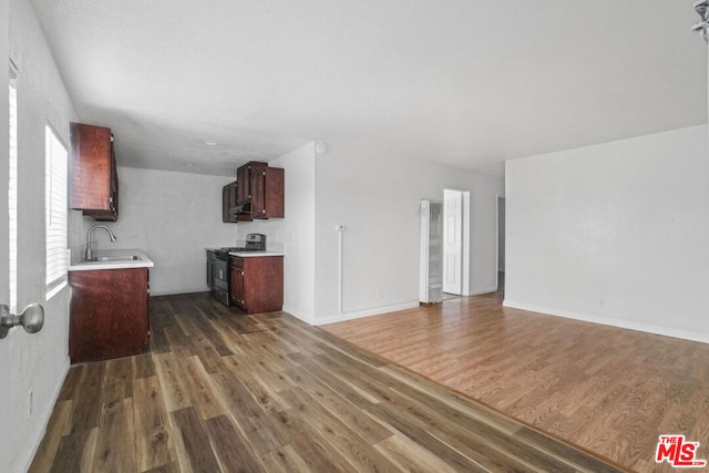 unfurnished living room with dark hardwood / wood-style flooring and sink