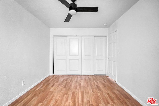 unfurnished bedroom featuring ceiling fan, a closet, and light hardwood / wood-style flooring