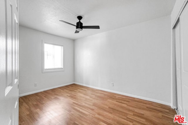 empty room with ceiling fan, a textured ceiling, and light hardwood / wood-style floors