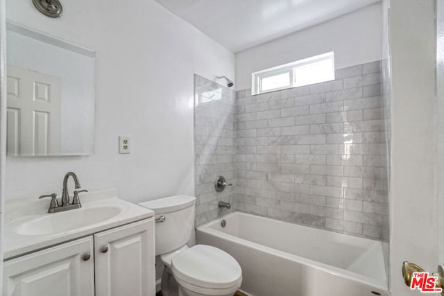 full bathroom with toilet, tiled shower / bath combo, and vanity