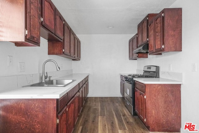 kitchen featuring sink, a textured ceiling, stainless steel gas range, and dark hardwood / wood-style flooring