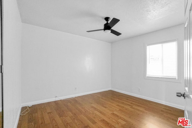 spare room featuring ceiling fan, hardwood / wood-style floors, and a textured ceiling