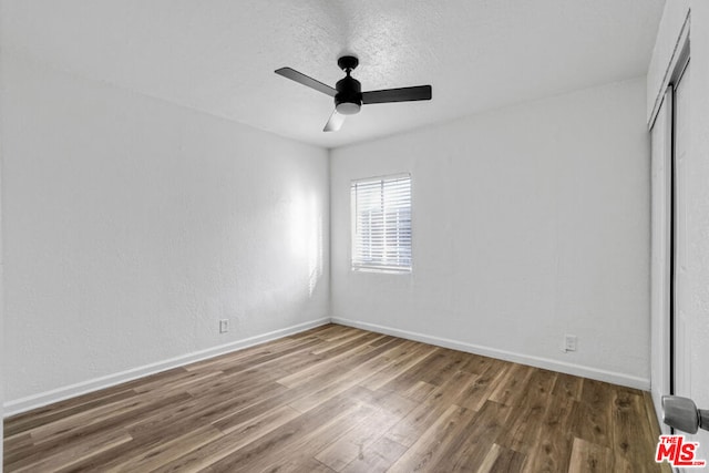 unfurnished bedroom with ceiling fan, a textured ceiling, and hardwood / wood-style flooring