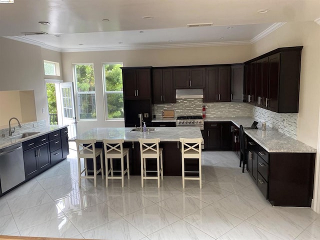 kitchen with sink, stainless steel appliances, backsplash, an island with sink, and a breakfast bar area