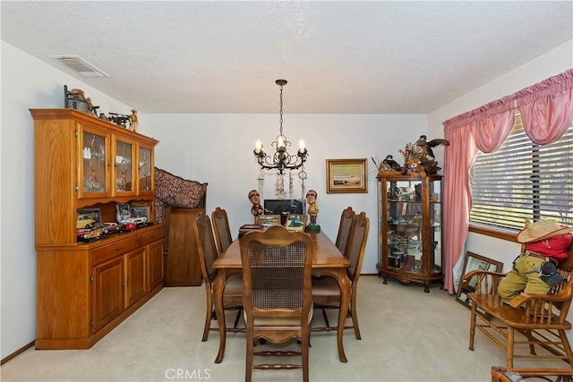 dining area featuring light carpet and an inviting chandelier