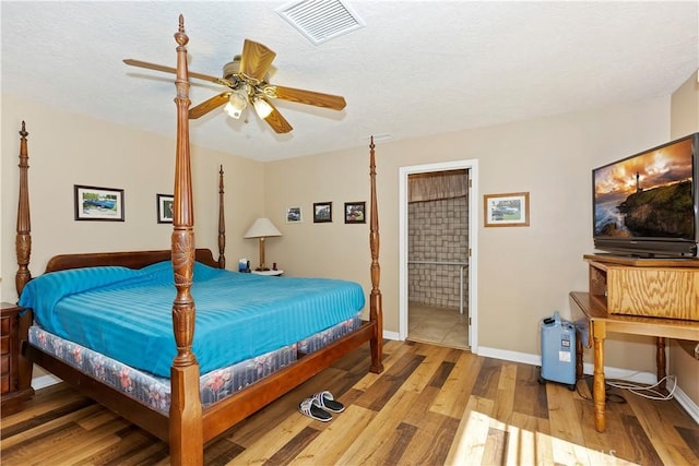 bedroom featuring connected bathroom, light hardwood / wood-style floors, and ceiling fan