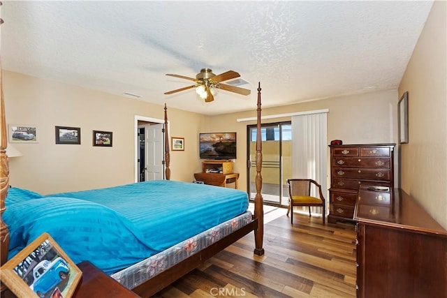 bedroom featuring a textured ceiling, ceiling fan, and dark wood-type flooring