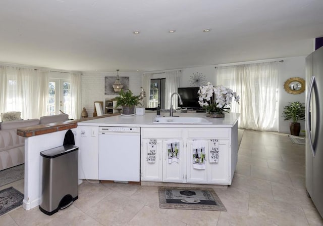 kitchen featuring a wealth of natural light, white cabinetry, dishwasher, and sink