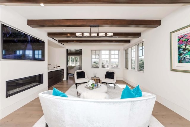 living room with beam ceiling and light hardwood / wood-style floors