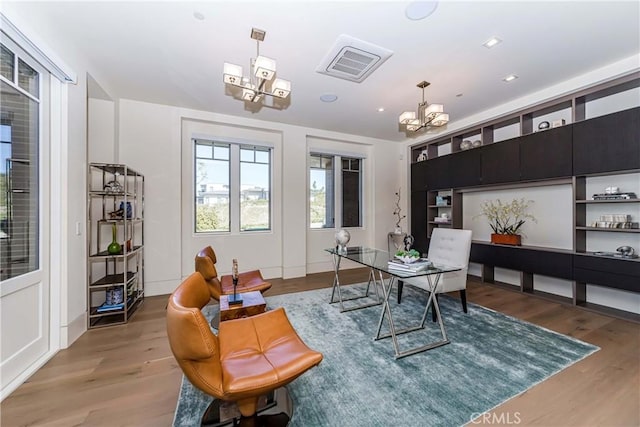 office with hardwood / wood-style flooring and a notable chandelier