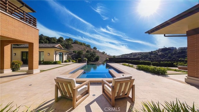 view of pool with a patio area and a mountain view