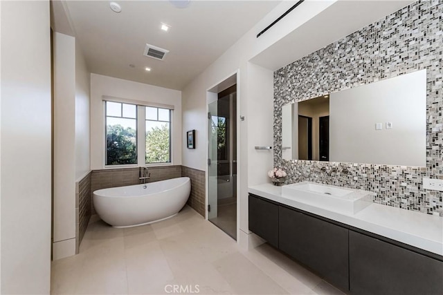 bathroom with tile patterned floors, vanity, separate shower and tub, and tile walls