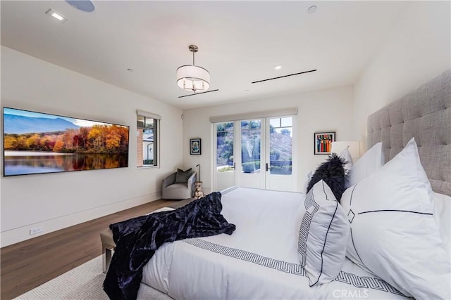 bedroom with access to outside, hardwood / wood-style floors, and french doors