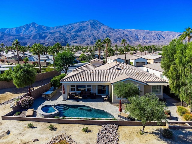 view of swimming pool with outdoor lounge area, a mountain view, an in ground hot tub, and a patio area